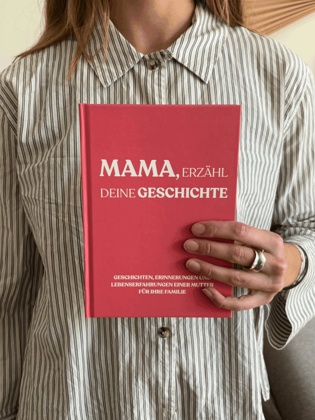 Frau hält das Erinnerungsbuch Mama, erzähl deine Geschichte von LebensBand.de