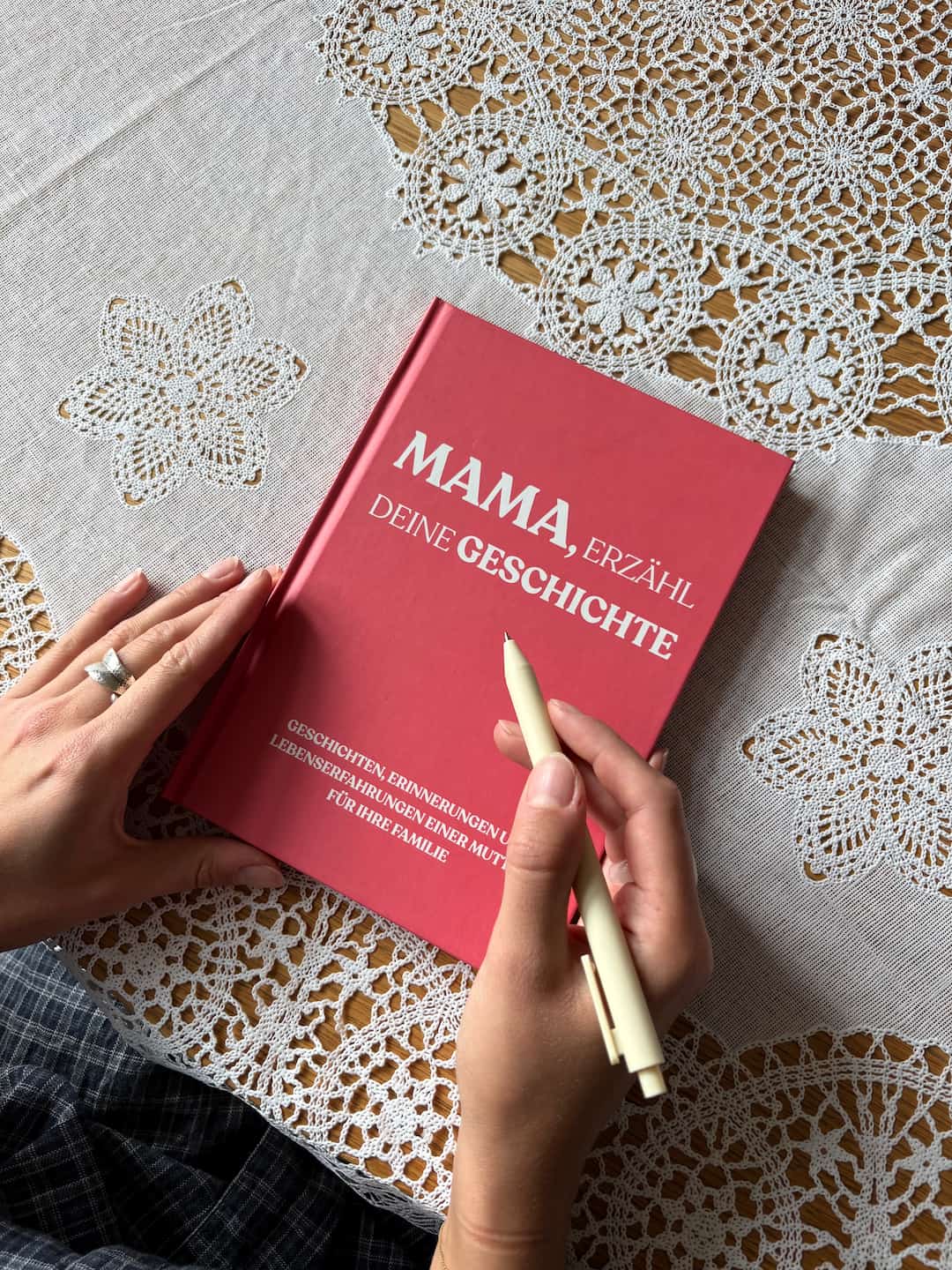 Frau hält das Erinnerungsbuch Mama, erzähl deine Geschichte mit einem Stift von LebensBand.de